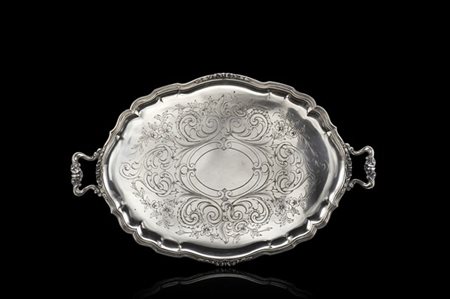 Vassoio biansato in argento di forma ovale con bordura scanalata decorata da ca