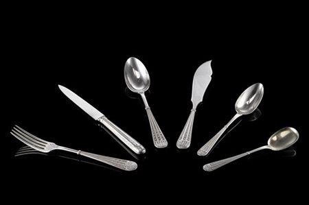 Servizio di posate in argento con manici scanalati e cesellati a campanule e mo