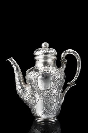 Caffettiera in argento a corpo cesellato a volute fogliate e fiori. Ansa a dopp