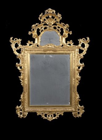 Specchiera in legno intagliato e dorato, cimasa centrata da cartella mossa con