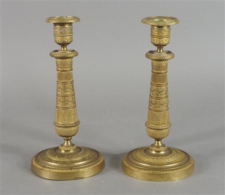 Paio di candelieri in bronzo dorato in stile Impero. H. cm. 23.