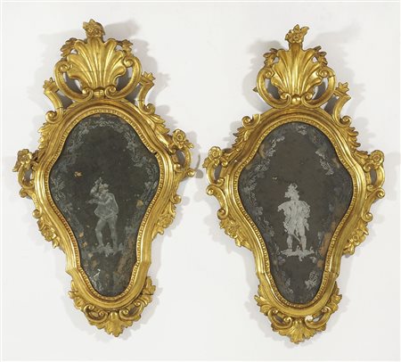 Coppia di specchierine in legno dorato scolpito, specchi incisi con figure....