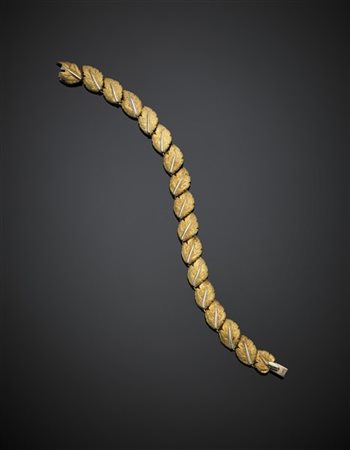 Bracciale in oro giallo e bianco in parte cesellato a guisa di foglie, g 29,45,