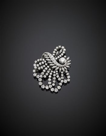 Spilla a volute in oro bianco e diamanti rotondi, al centro diamante di ct. 0,5