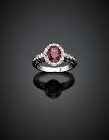 Anello in oro bianco con granato ovale di ct. 3 circa e diamanti, g 11,43 misur