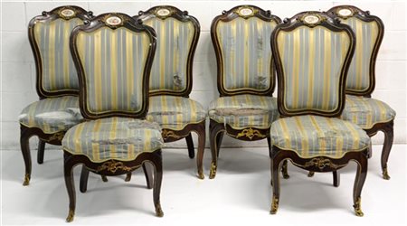 Gruppo di sei sedie con schienali sagomati decorati da applicazioni in metallo