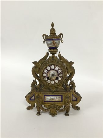 Pendola da tavolo in bronzo con decoro ad aquile e volute, inserti in porcellan