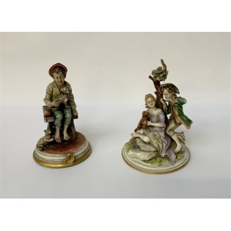 Lotto di due sculture in porcellana policroma raffiguranti fanciulli con animal