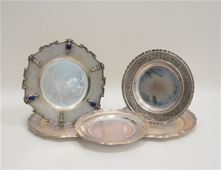 Gruppo di cinque piatti in argento di diversa fattura tra cui due di forma sago