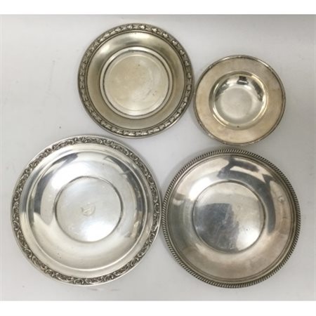 Lotto di quattro piattini in argento con bordi decorati. Titolo 800 (g 585 ca.)