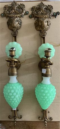 Coppia di appliques in bronzo ad una fiamma decorate a teste di ariete e in opa