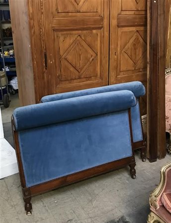 Letto a barca in mogano con montanti intagliati. Imbottitura in velluto azzurro