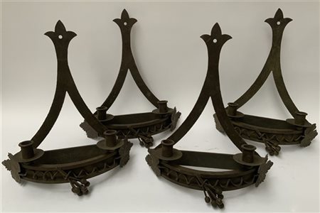 Gruppo di quattro candelabri a due fiamme in ferro battuto con decoro a pampini