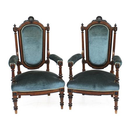 Coppia di poltrone di gusto eclettico in legno intagliato con profili ebanizzat