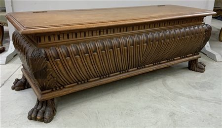 Cassapanca in legno intagliato con decoro a baccellature e piedi a zampa ferina