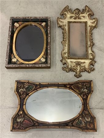 Lotto di tre specchiere con cornici in legno intagliato e dipinto di fatture e
