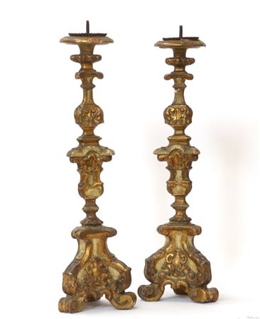 Coppia di candelieri tripodi in legno intagliato, dorato e laccato, secolo XVII