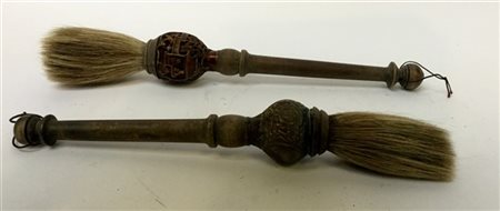 Due pennelli per calligrafia con manici in legno intagliati a motivi diversi (h