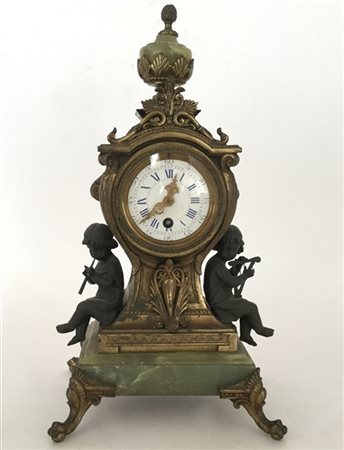 Pendola in onice e antimonio, decorato da due putti musicanti, sormontato da va