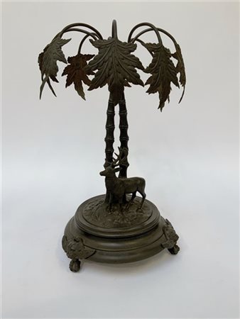 Centrotavola in metallo brunito con alberi e cervo e base decorata a teste leon