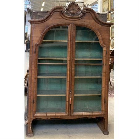 Alzata a due ante in vetro sormontata da cimasa di forma mossa scolpita a volut