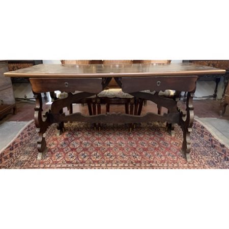 Tavolo scrittoio in noce con due cassetti sottopiano, sostegni a lira e travers