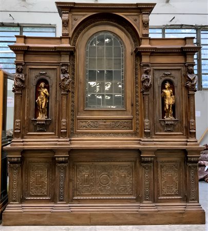 Libreria a due corpi in legno intagliato e scolpito con figure in altorilievo,