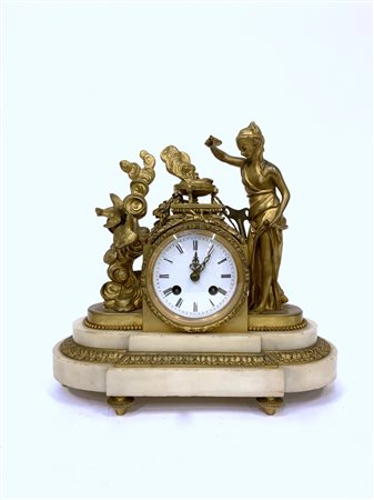 Pendola da tavolo in bronzo dorato decorata con figura di vestale a tuttotondo