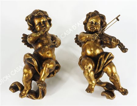 Coppia di putti musicanti dorati. H. cm. 40.