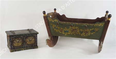 Lotto di 2 modelli di culla basculante e cassapanca, in legno con decori...