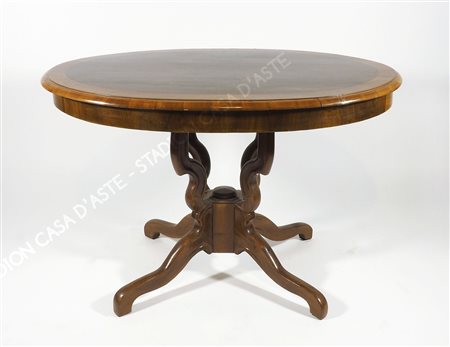 Tavolo ovale in legno su gambe mosse. cm. 78x120x76.