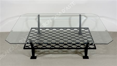 Tavolo basso in ferro battuto nero con piano in cristallo.