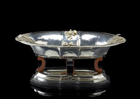 Grande centrotavola di forma sagomata in argento martellato decorato da fregi a