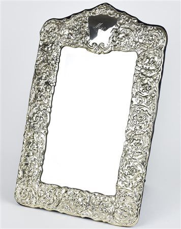 CORNICE IN ARGENTO decorata a racemi vegetali e monogramma M.N., con specchio...