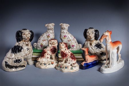 Gruppo di otto cani in porcellana e ceramica policroma, secolo XX