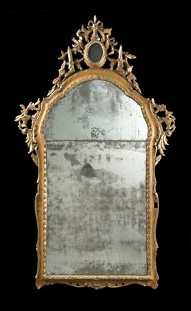 Specchiera di forma mossa in legno intagliato, laccato e dorato con cimasa traf