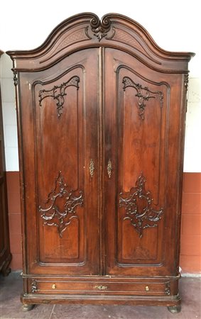 Armadio a due ante cuspidate e intagliate a volute, cassetto alla base, cimasa