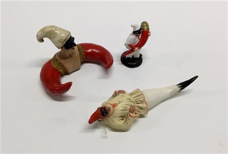 Lotto composto da tre sculture in materiali diversi raffiguanti pulcinella con