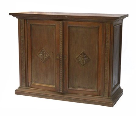 Credenza a due ante pannellate e decorate a fregio intagliato a volute. Montant