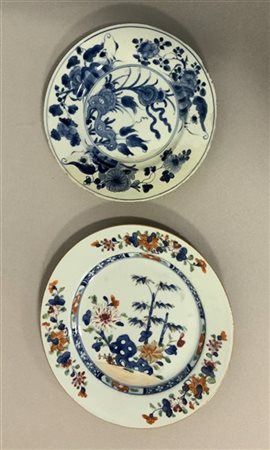 Due piatti in porcellana a motivi floreali, uno a decoro bianco e blu, l'altro