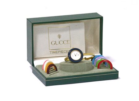 GUCCI 
Orologio in metallo color oro con scelta di ghiere multicolor sostituibi