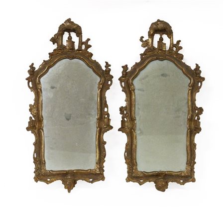Coppia di antiche specchierine di forma sagomata in legno dorato e intagliato a