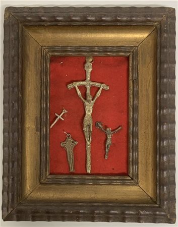 Collezione di cinque crocefissi in bronzo e metallo di diversa epoca, in cornic