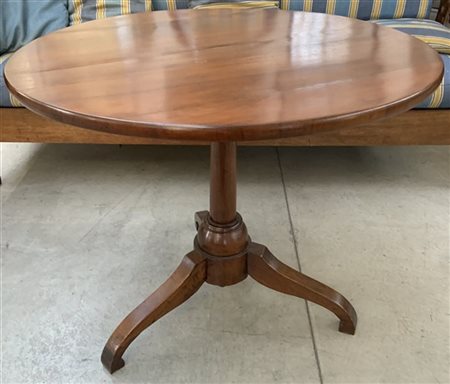 Tavolo con piano di forma tonda in mogano. Sostegno a colonna su tre piedi sago