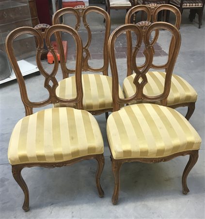 Gruppo di quattro sedie in noce con schienale a giorno a listelli sagomati. Riv