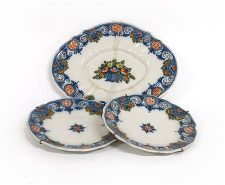 Lotto di un vassoio ovale e due piatti in maiolica a bordo sagomato decorati in
