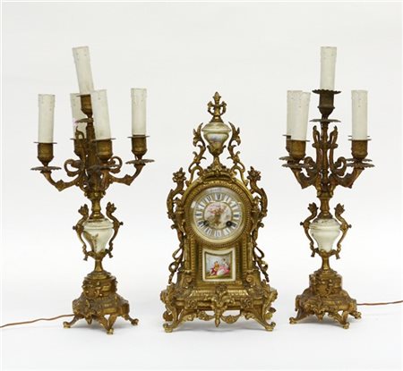 Trittico da camino in bronzo, composto da pendola e coppia di candelieri a cinq