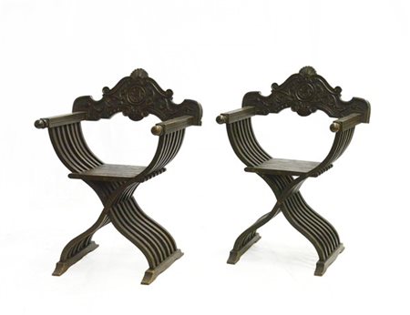 Coppia di poltrone Savonarola con schienale intagliato a volute fogliate (difet