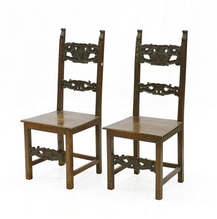 Coppia di sedie con schienale e fascia intagliate e traforate a volute fogliate