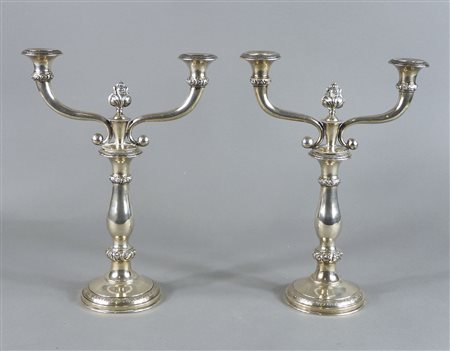 Paio di candelieri in argento a 2 fiamme. H. cm. 34. gr. 800.